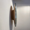 The Present - Year (steel and glass) flush-mounted on wall in profile revealing the pressure fit brushed stainless steel rims and convex glass.